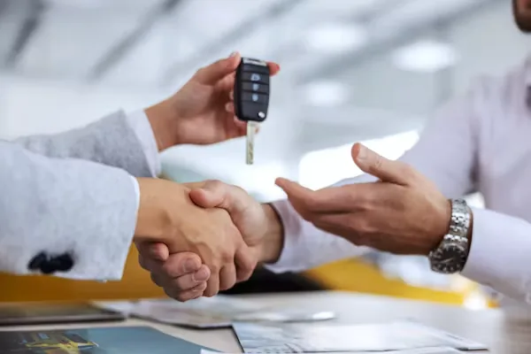 Poignée de main et remise des clés d'une voiture de location