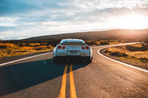Voiture sur une route au coucher du soleil