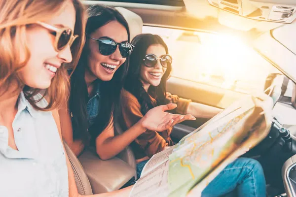 Voyageuses consultant une carte dans leur voiture de location